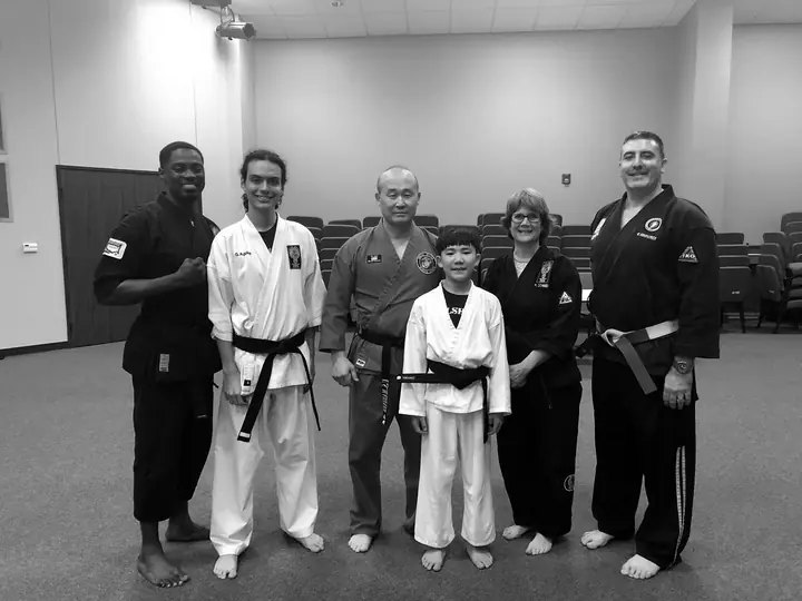Fulshear Family Karate instructors and black belts standing together with a young student